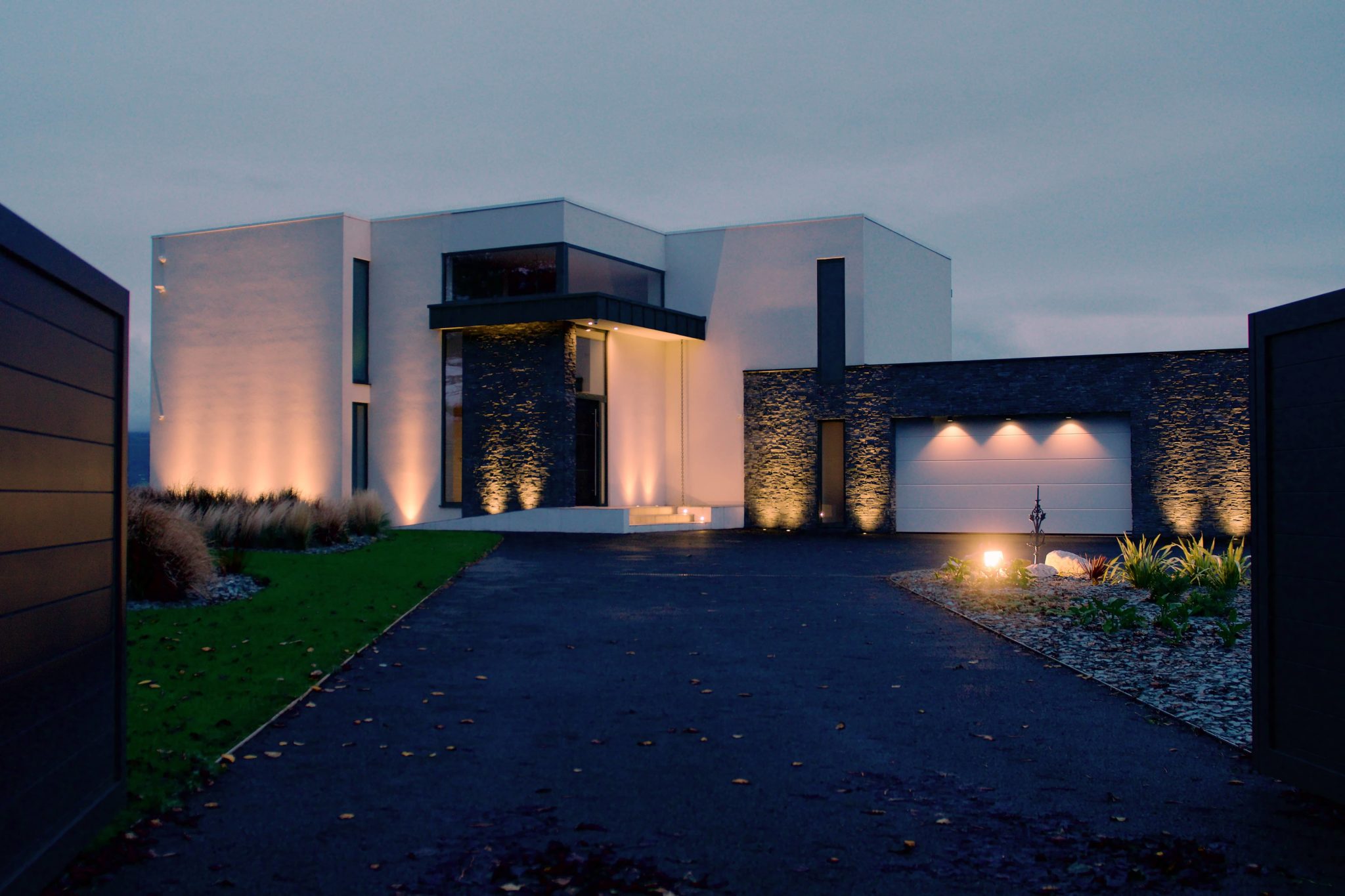 a modern house lit up at night in the evening.